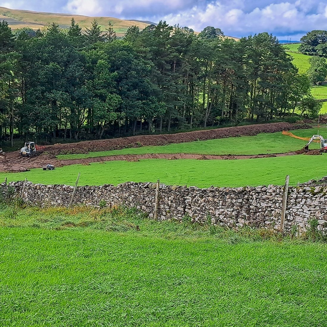 Diggers working within the new river channel to protect the hay meadow.