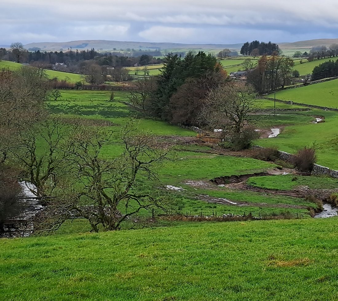A valley landscape with undulating hills. Scandal Beck can be seen on the left, and the new river wiggling channel is on the right