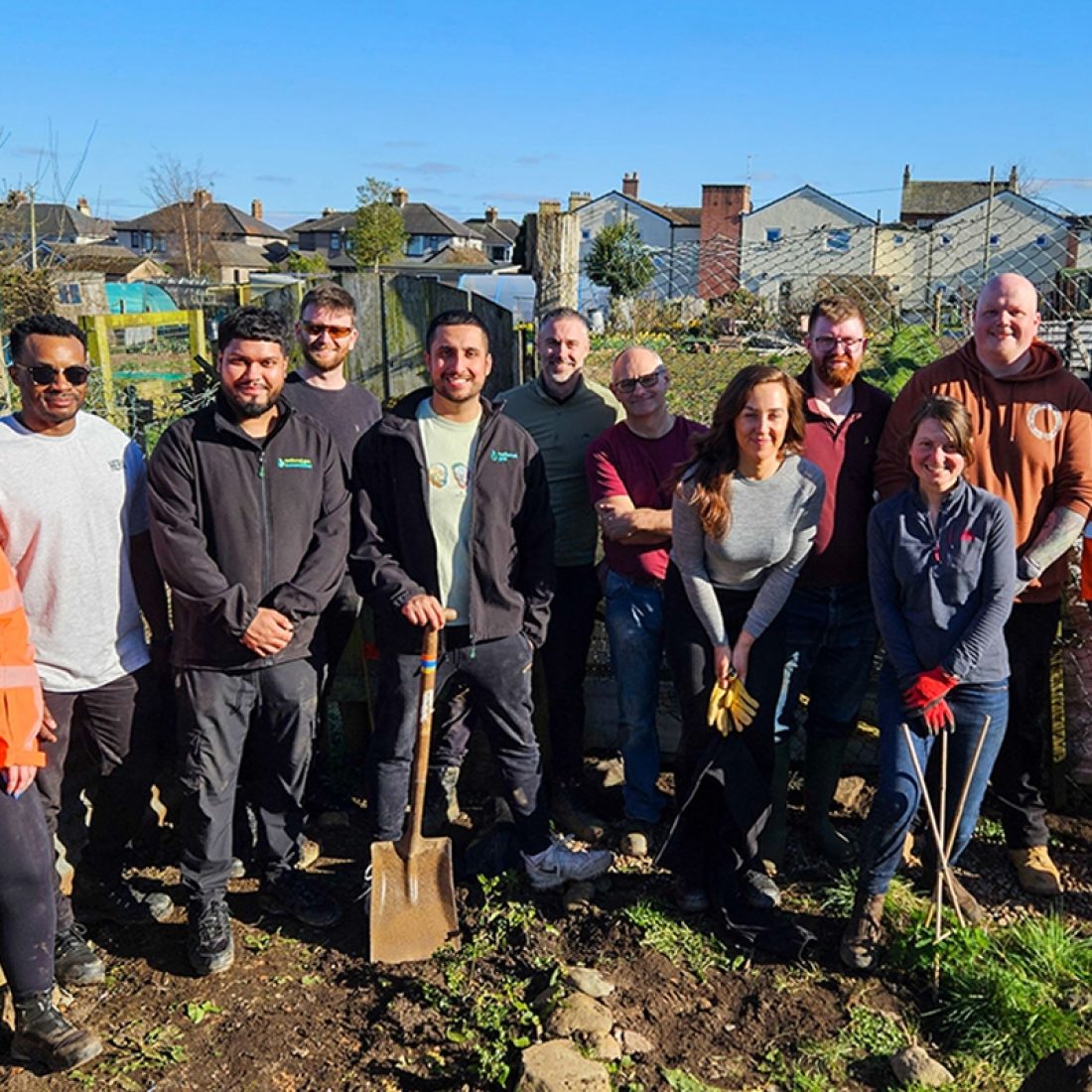 A group photograph of all of the members of British Gas staff following a day spent a day volunteering at the Penrith community tree nursery to install new drainage.