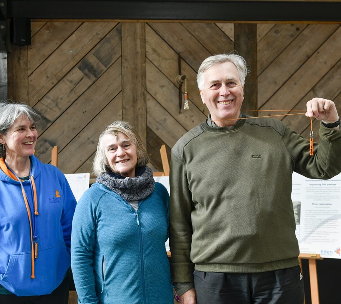 ERT staff pose for picture with volunteer holding a golden whistle aloft.