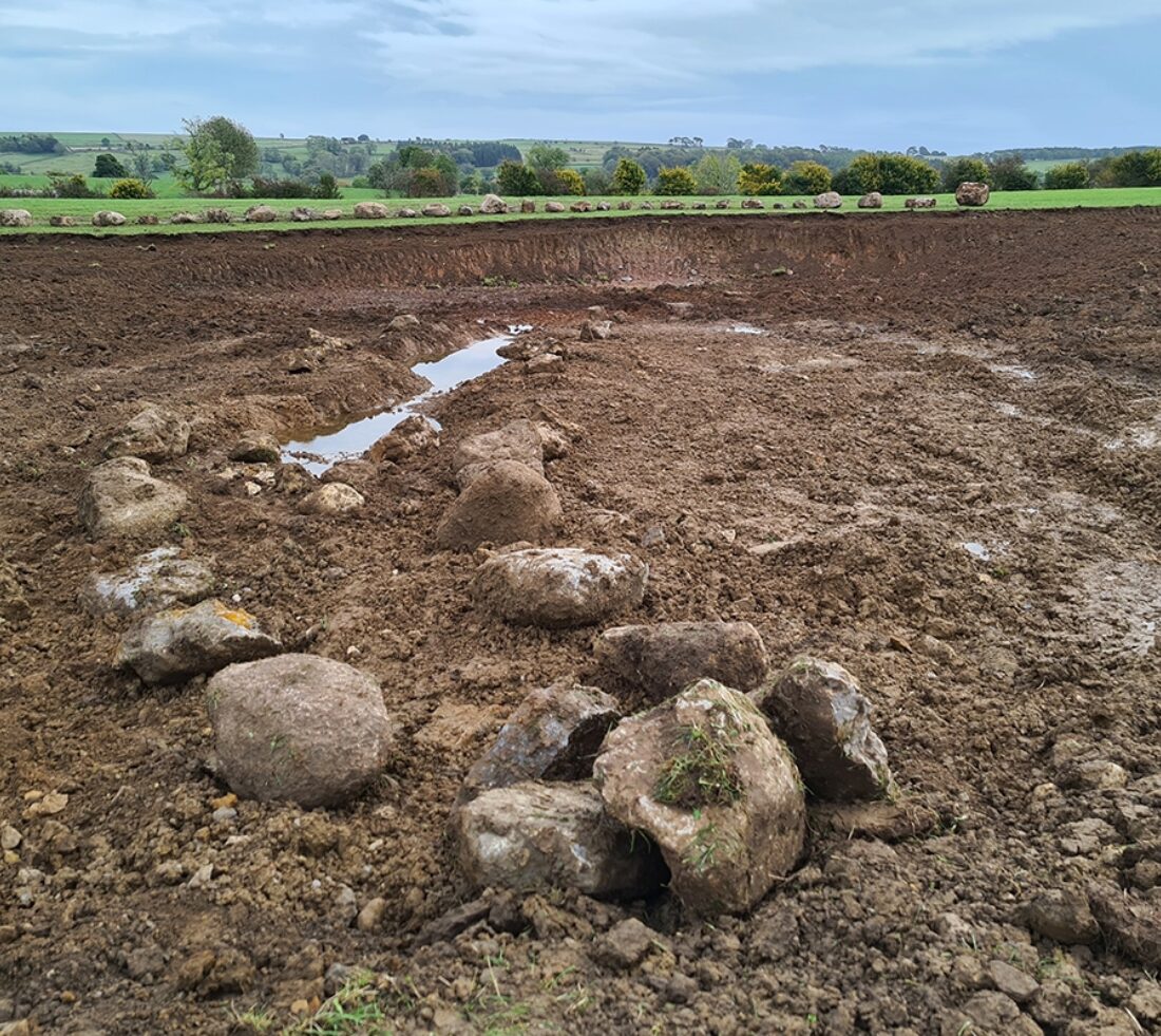 Close up view of completed groundworks and excavations, creating a large bowl in stony soil prior to water ingress.