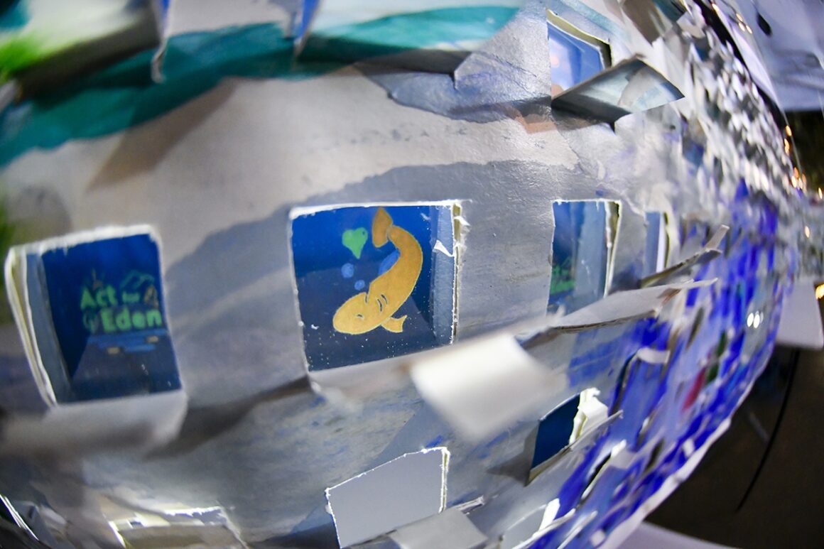 Close up of a white board with square clear windows featuring a drawing of a yellow fish.