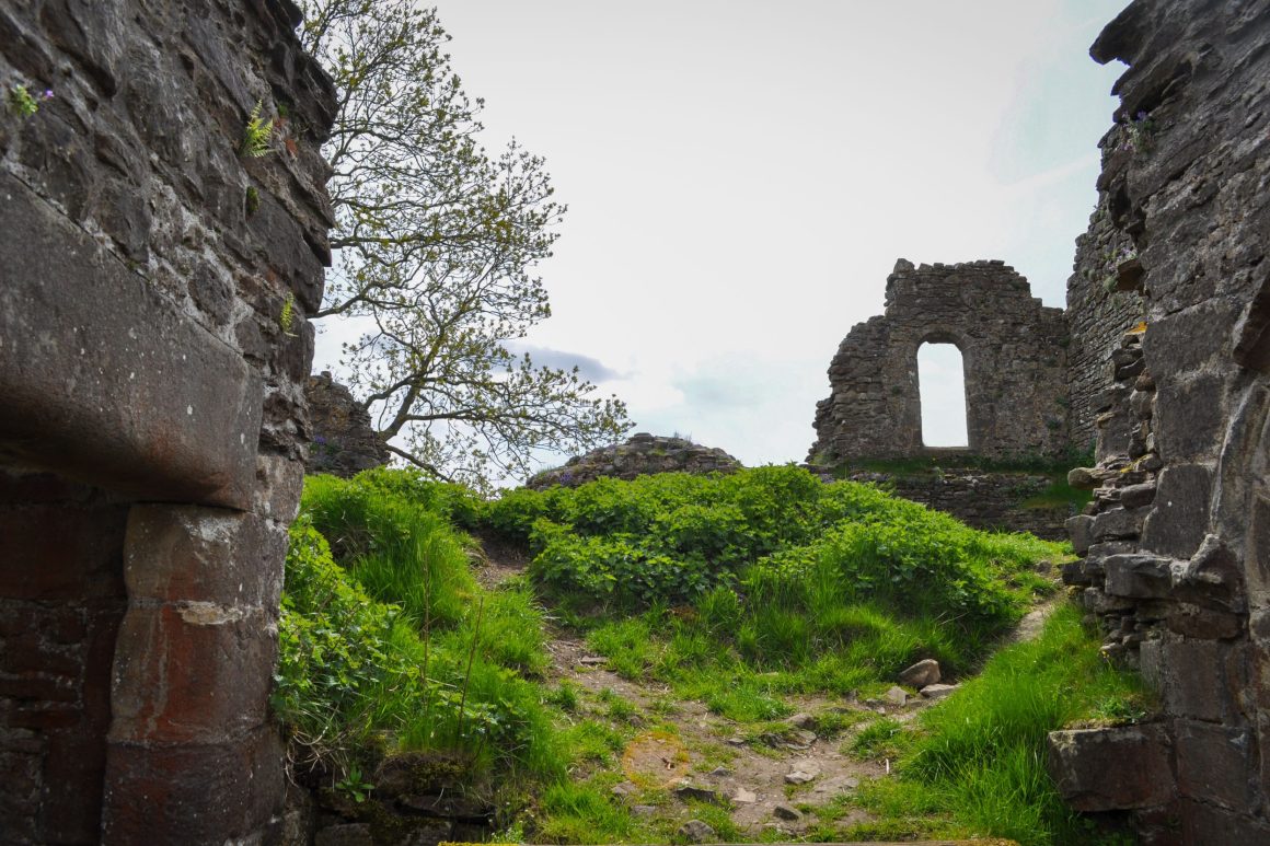 Derelict stone walls of Pendragon Castle featuring intact doorway with thick stone lintels.