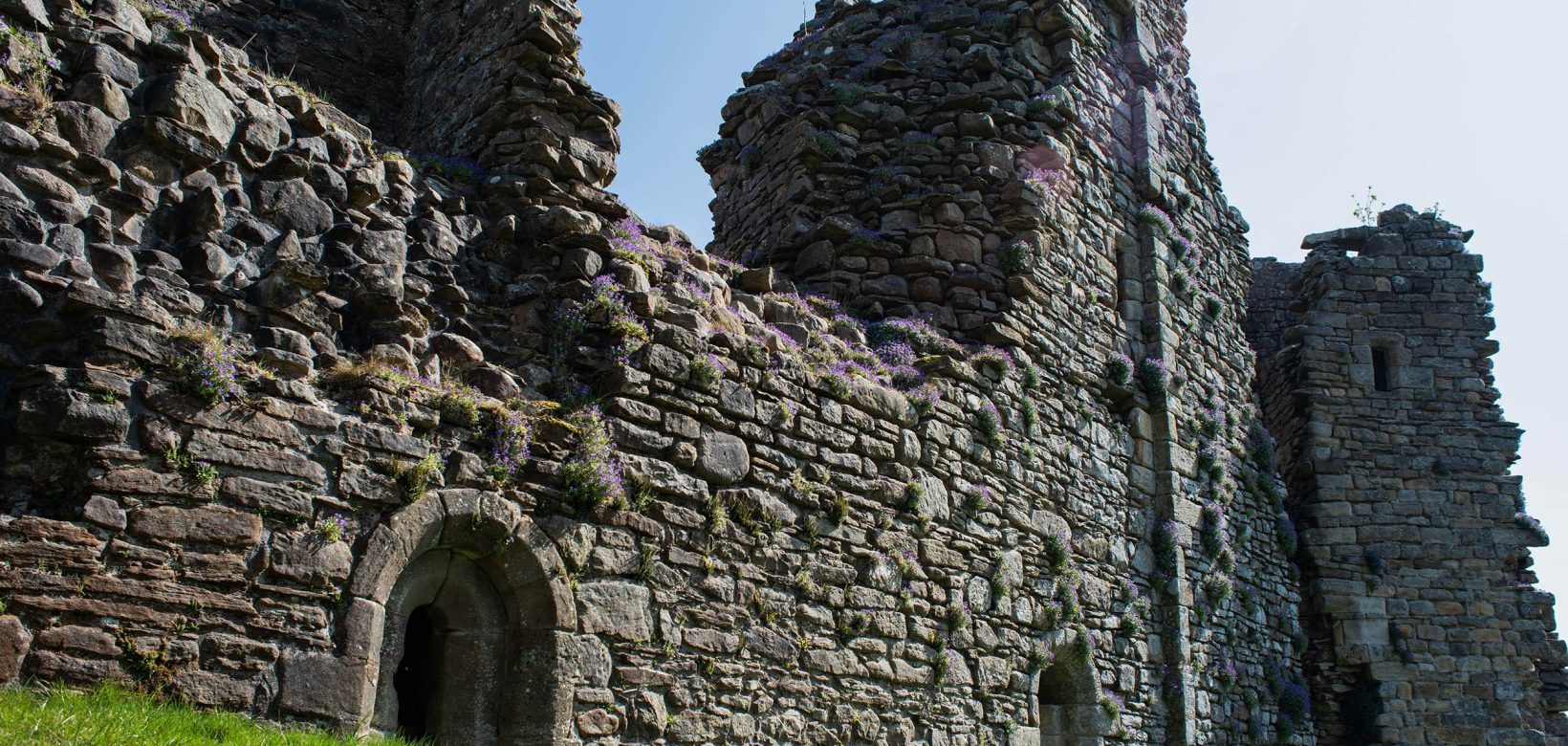 Derelict stone walls of Pendragon Castle featuring arched doorways .