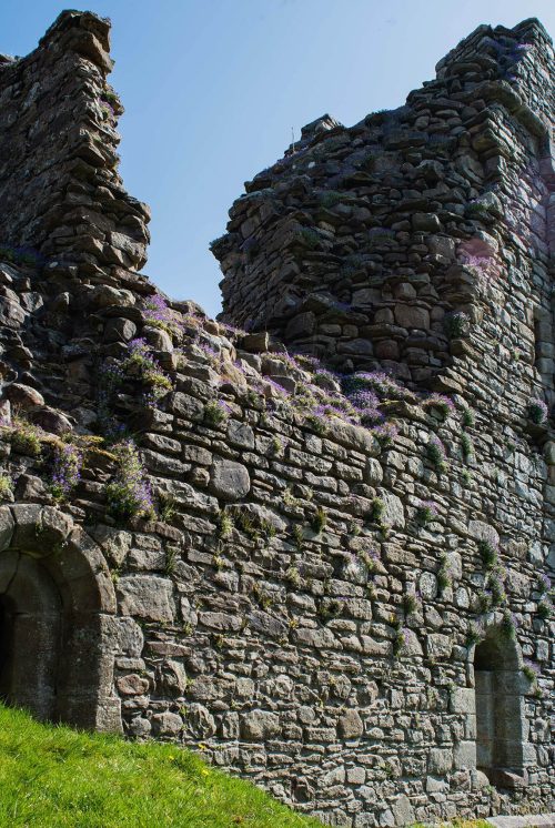 Derelict stone walls of Pendragon Castle featuring arched doorways .