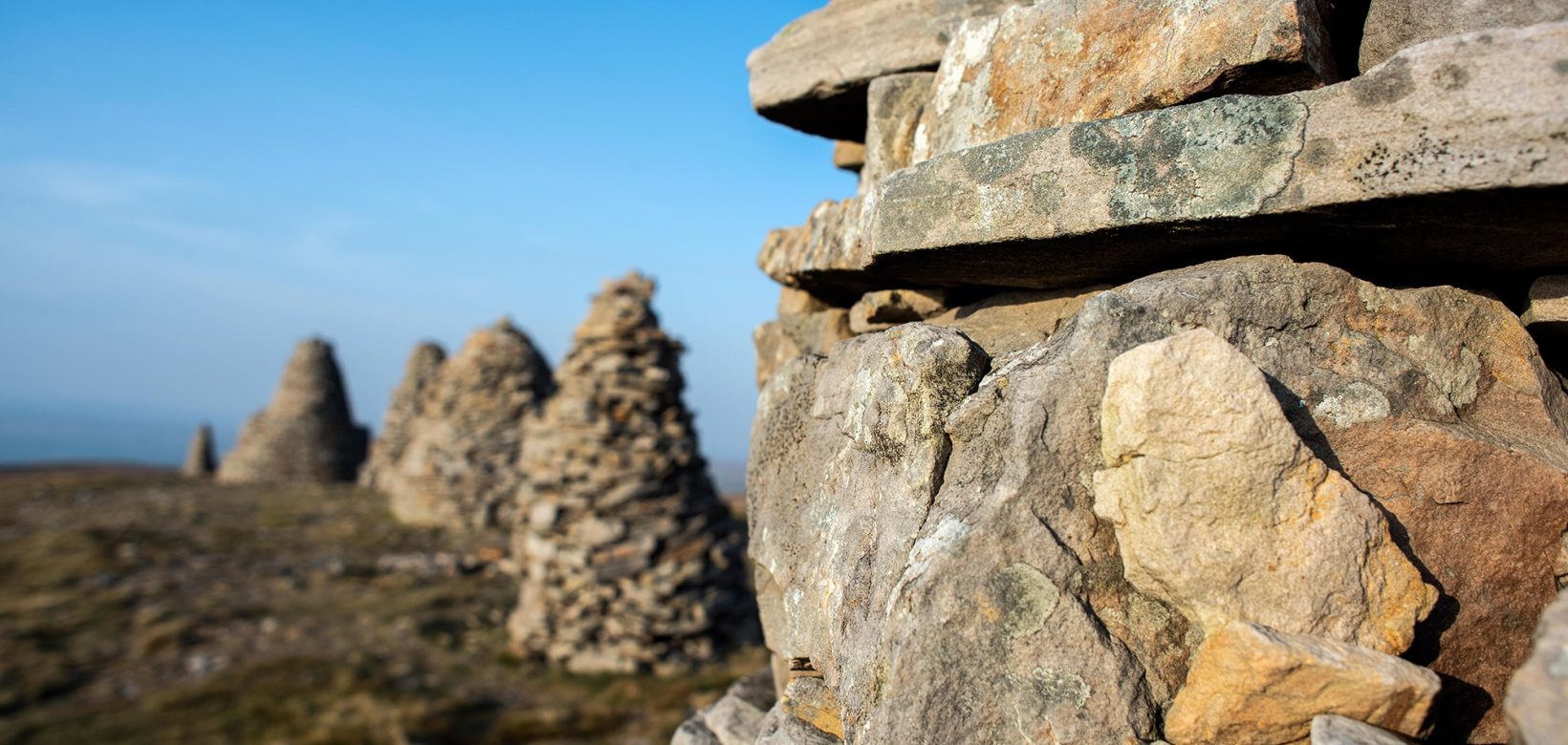 Five stone cairns are shown on top of a hill