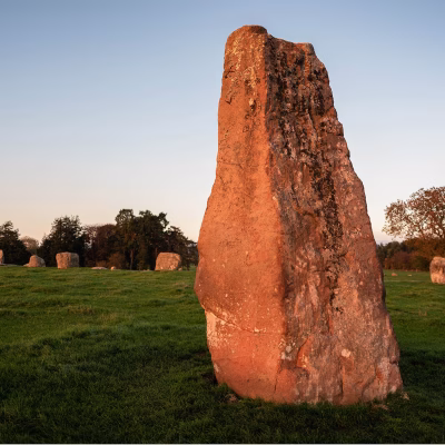 A row of stones makes a circle. In the foreground is a much taller stone, called Long Meg that is outside the circle.
