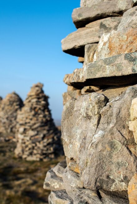 Five stone cairns are shown on top of a hill