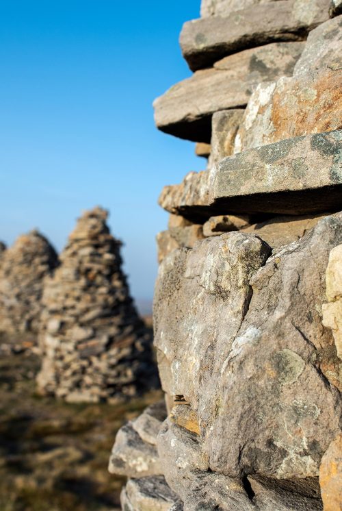 Five stone cairns are shown on top of a hill