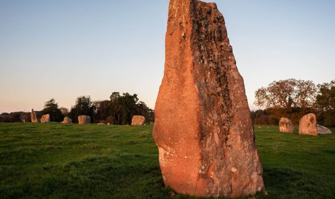 A row of stones makes a circle. In the foreground is a much taller stone, called Long Meg that is outside the circle.