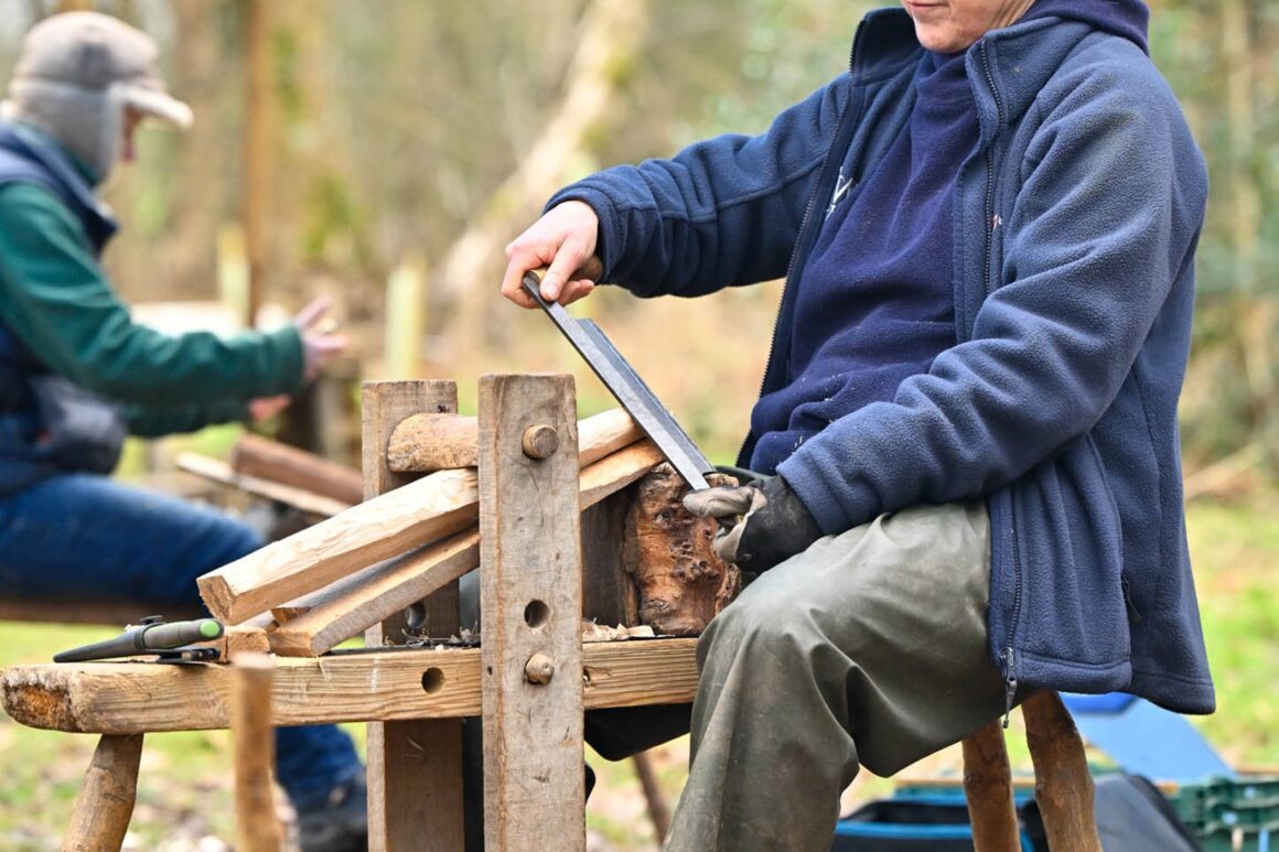 ERT staff member using a shaving horse in the construction of a wooden bench.