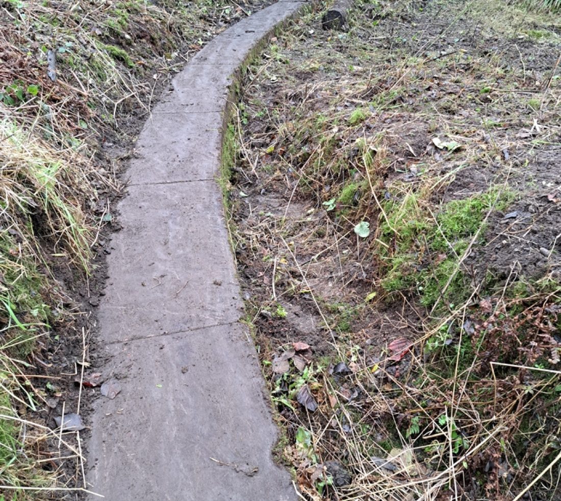 A circular section of stone revealed by the clearance of undergrowth. This was the outer ring of a railway turntable once in use on the site.