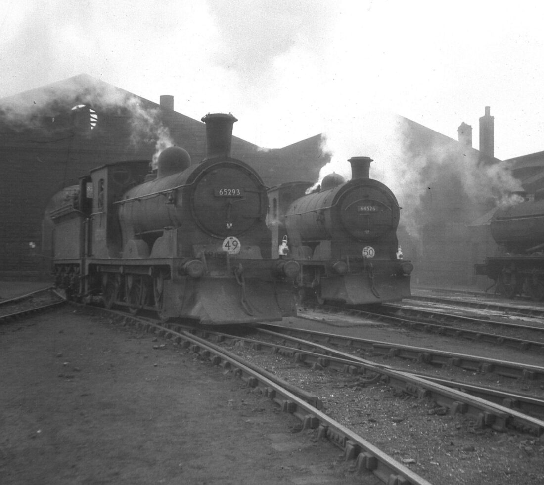 Two steam engines on tracks in front of train engine sheds at Engine Lonning.