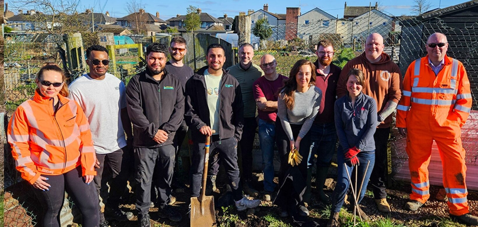 A group of volunteers from the Penrith community tree nursery posing in sunshine for a picture after spending the day installing French drains at the site.