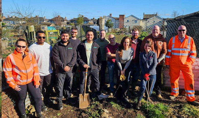 A group of volunteers from the Penrith community tree nursery posing in sunshine for a picture after spending the day installing French drains at the site.