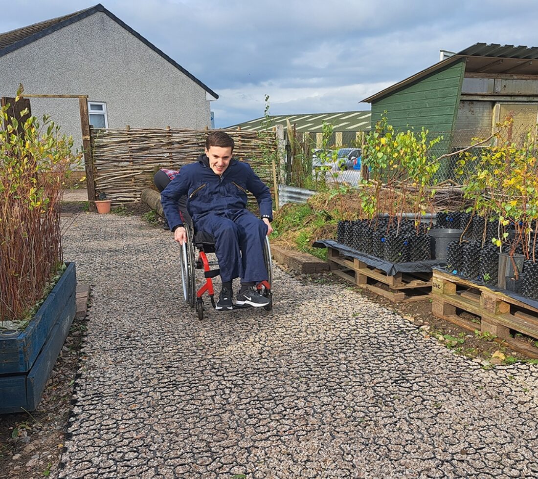 A wheelchair user testing out a newly-laid accessible path at the Eden Community Tree Nursery