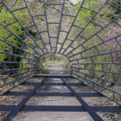 Wrought iron gate at the entrance of Engine Lonning. The metalwork shows the tunnel and train tracks that used to run down the path of the lonning