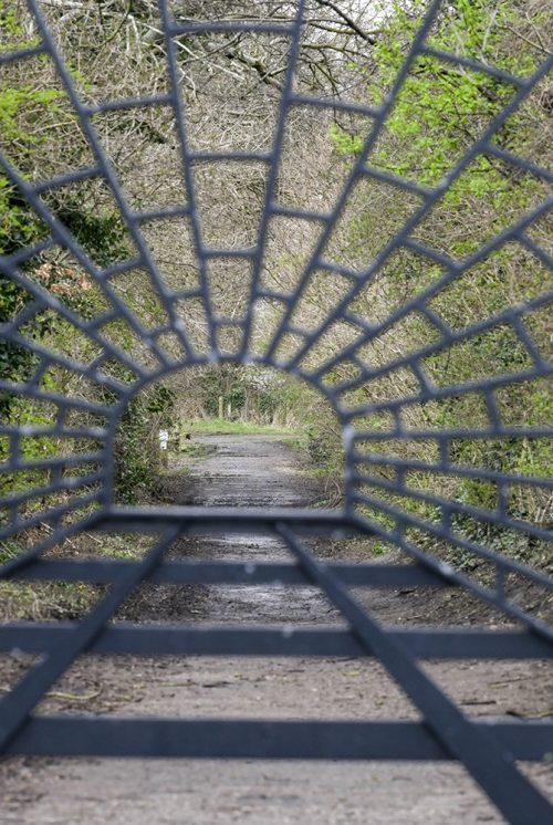 Wrought iron gate at the entrance of Engine Lonning. The metalwork shows the tunnel and train tracks that used to run down the path of the lonning