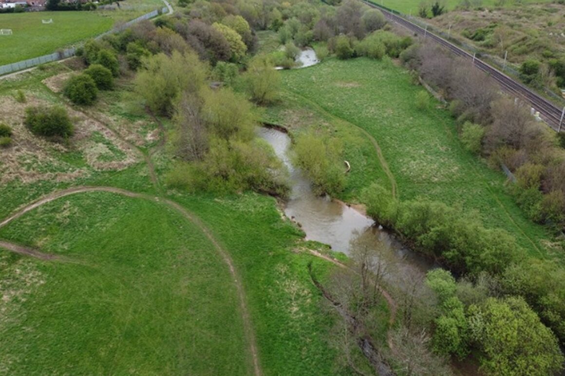 Aerial view of the river Petteril, showing the extent of the Petteril vale site, the path of the river through the grassland and its proximity to the railway line running along its border.