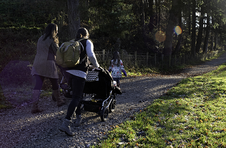 Family with a pushchair walking by the river