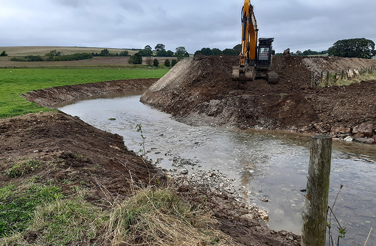 Digger backfilling the old river channel